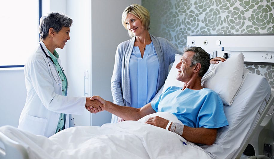 Female doctor shaking the hand of a recovering male patient after Blue Light Cystoscopy procedure