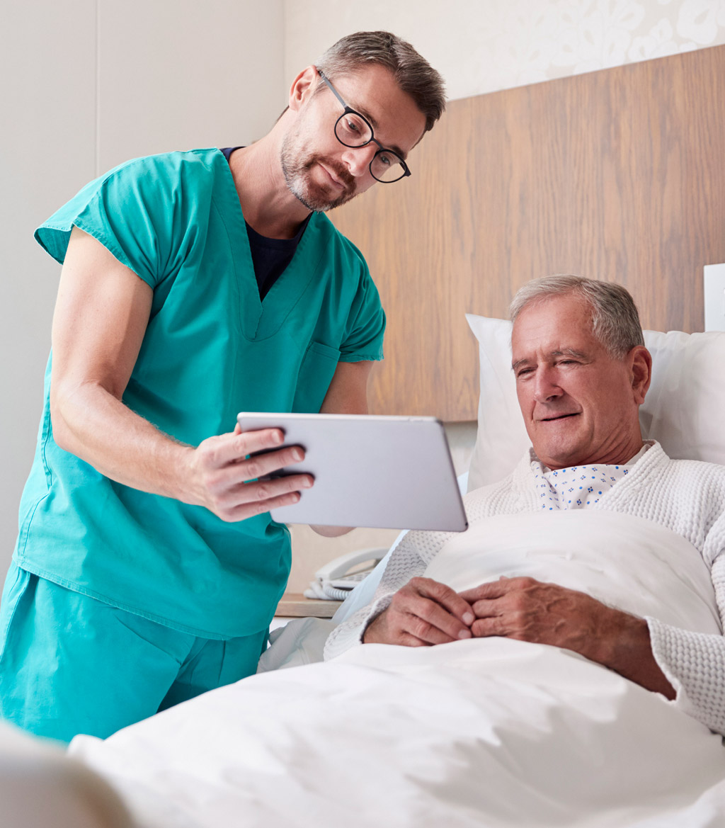 Surgeon-using-a-tablet-to-explain-the-transperineal-biopsy-procedure-to-male-patient